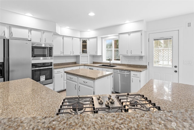 kitchen featuring stainless steel appliances, white cabinets, and a center island