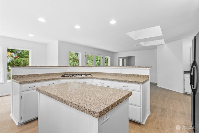 kitchen featuring white cabinets, light wood-type flooring, and a kitchen island