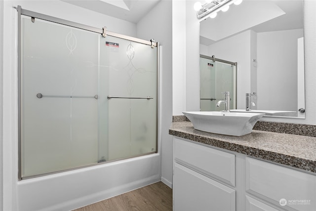 bathroom featuring shower / bath combination with glass door, wood-type flooring, and vanity