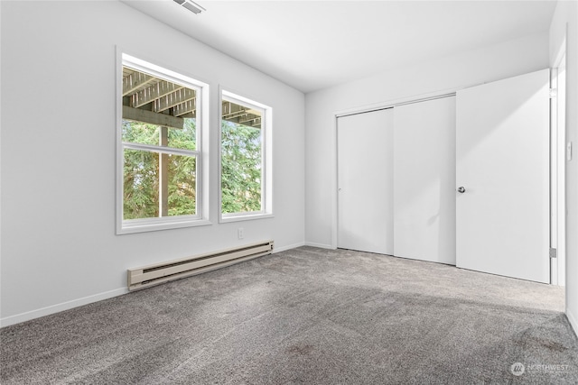 unfurnished bedroom featuring a closet, a baseboard heating unit, and carpet