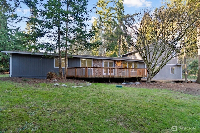 rear view of house featuring a yard and a deck