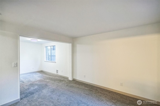 spare room featuring baseboards and carpet floors