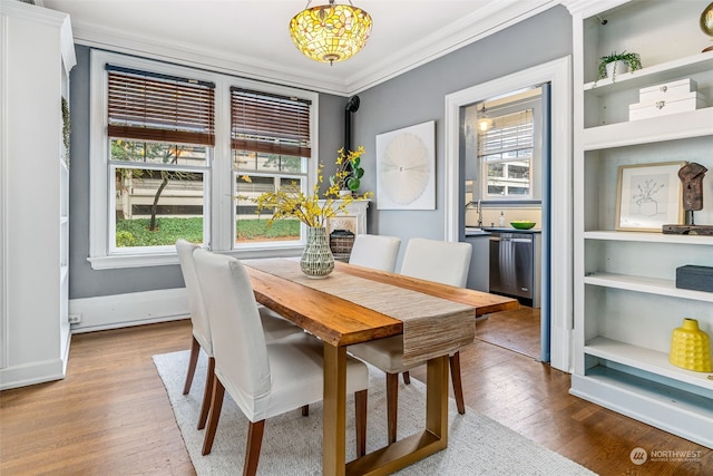 dining area with crown molding and light hardwood / wood-style flooring