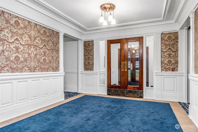 foyer with ornate columns, hardwood / wood-style floors, and crown molding