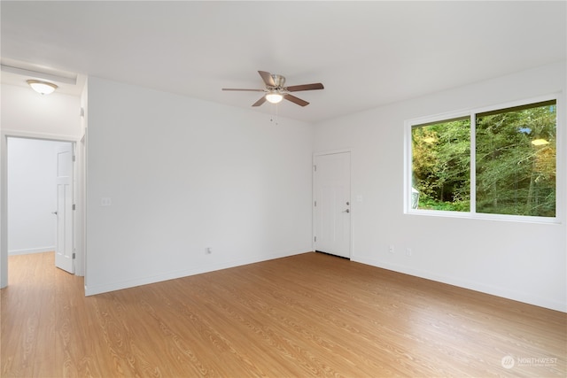 spare room with ceiling fan and light wood-type flooring