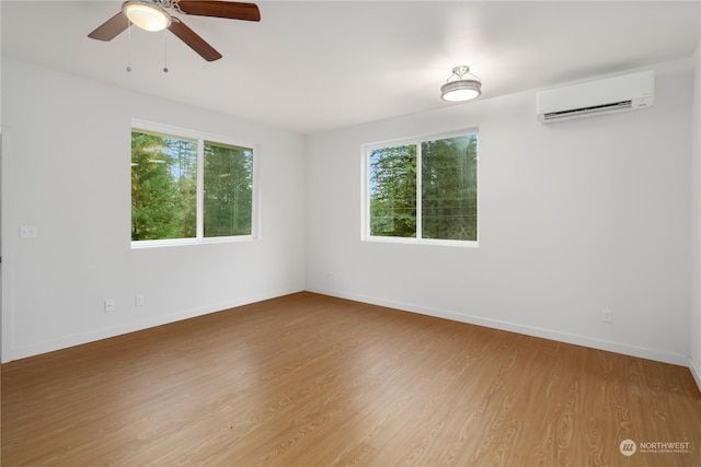 empty room featuring ceiling fan, hardwood / wood-style flooring, and a wall mounted air conditioner