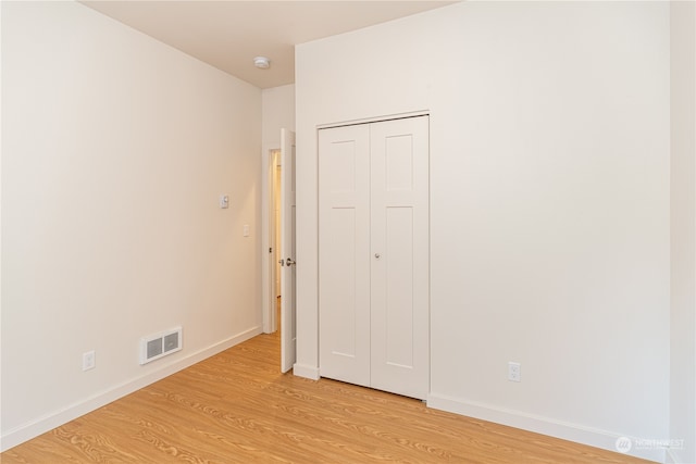 unfurnished bedroom featuring a closet and light hardwood / wood-style floors