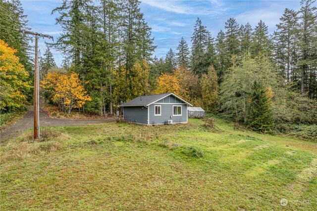 161 Oak St, Quilcene, WA 98376 - view of grassy yard featuring an outdoor structure and a forest view