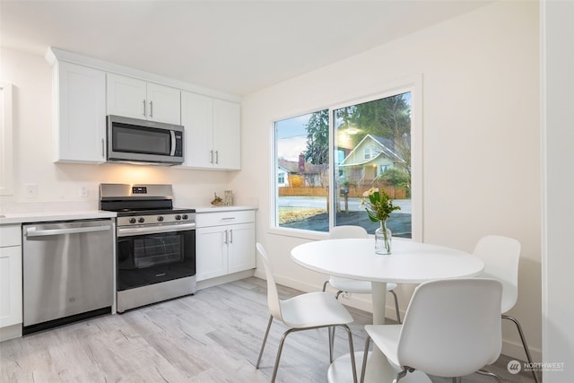 kitchen featuring stainless steel appliances, light wood-type flooring, and white cabinets