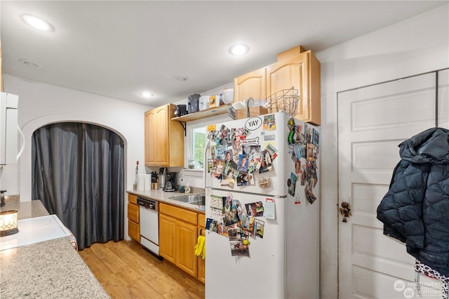 kitchen with light hardwood / wood-style floors, light brown cabinets, and white appliances