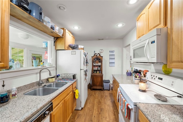 kitchen with white appliances, light hardwood / wood-style flooring, sink, and light stone counters