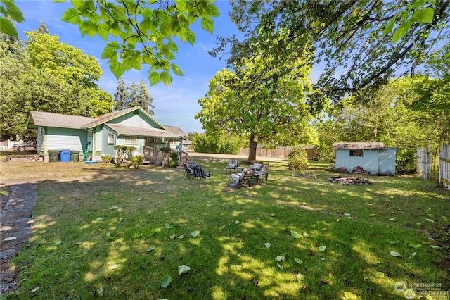 view of yard with an outdoor fire pit and a storage shed