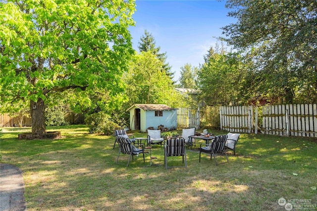 view of yard featuring a storage shed and an outdoor fire pit