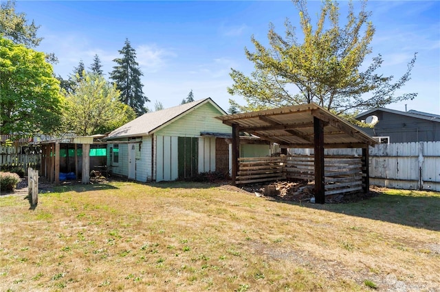 back of property with an outbuilding and a yard