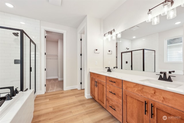 bathroom with hardwood / wood-style flooring, vanity, and walk in shower