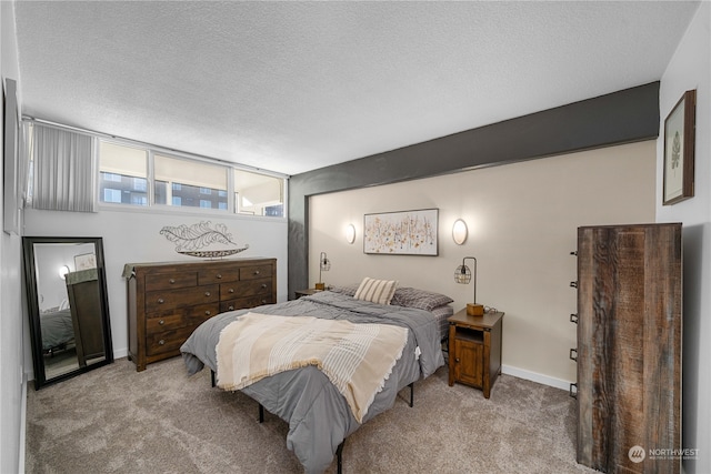 bedroom with a textured ceiling and light carpet