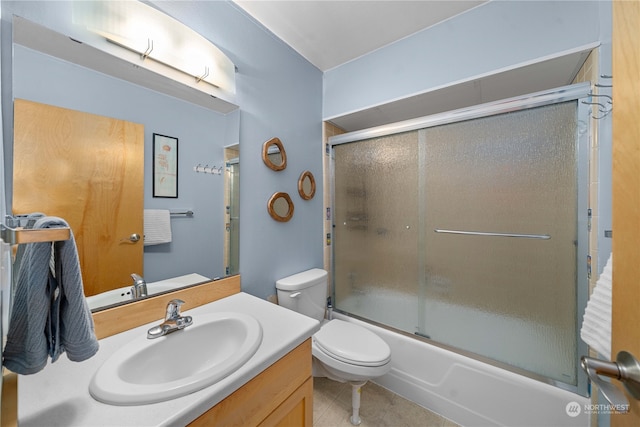 full bathroom featuring vanity, enclosed tub / shower combo, tile patterned flooring, and toilet