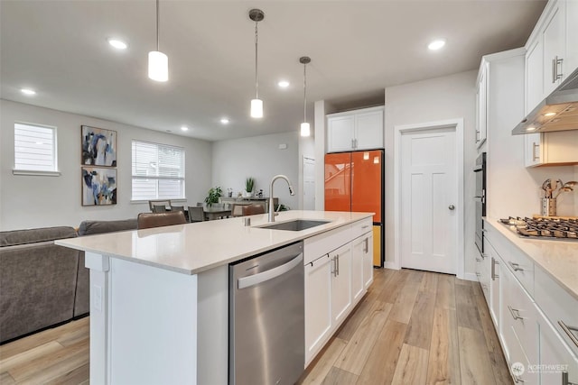 13307 Pines Ln E, Puyallup, WA 98374 - kitchen featuring stainless steel appliances, open floor plan, a sink, light wood finished floors, and recessed lighting