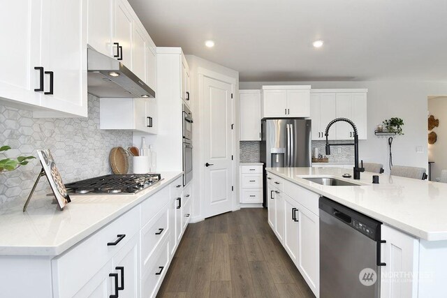 1121 SE 33rd St, Battle Ground, WA 98604 - kitchen with under cabinet range hood, dark wood-style flooring, a sink, white cabinets, and appliances with stainless steel finishes