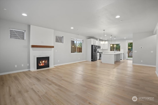 unfurnished living room featuring light hardwood / wood-style floors and a healthy amount of sunlight