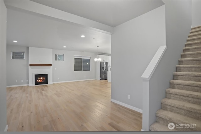 unfurnished living room featuring light hardwood / wood-style floors and a chandelier