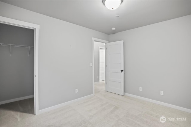 unfurnished bedroom featuring light colored carpet and a closet