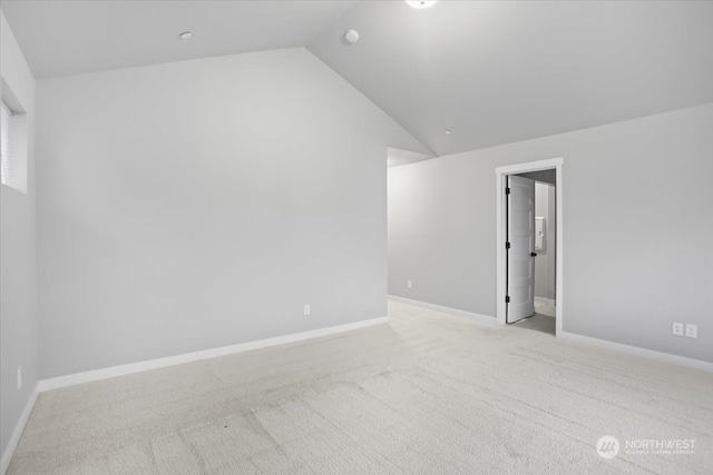 carpeted empty room featuring lofted ceiling