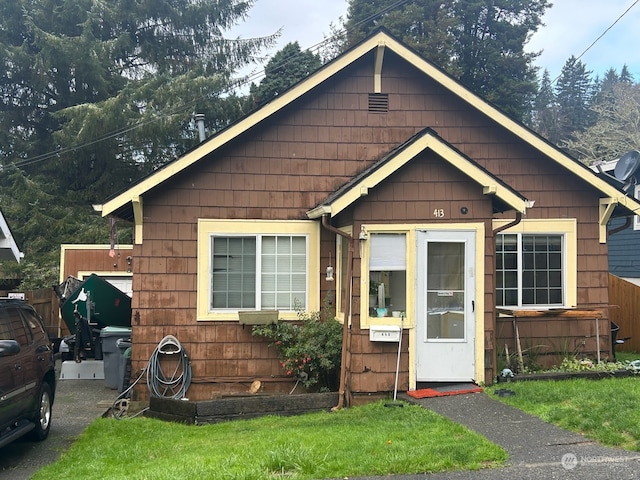 bungalow-style home with a front yard