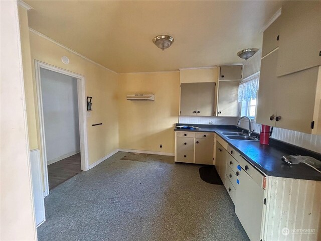 kitchen with sink, a wall unit AC, and cream cabinetry