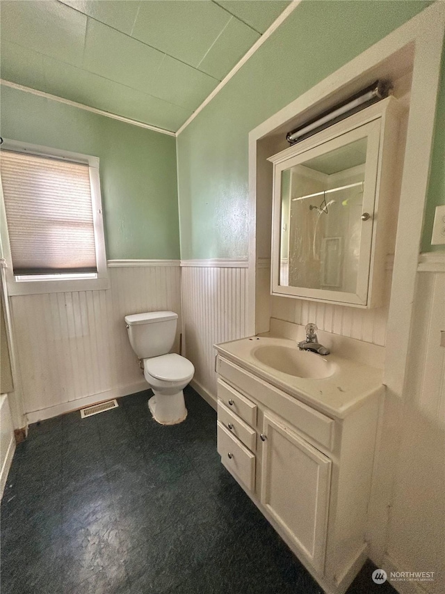 bathroom featuring vanity, a shower, ornamental molding, and toilet