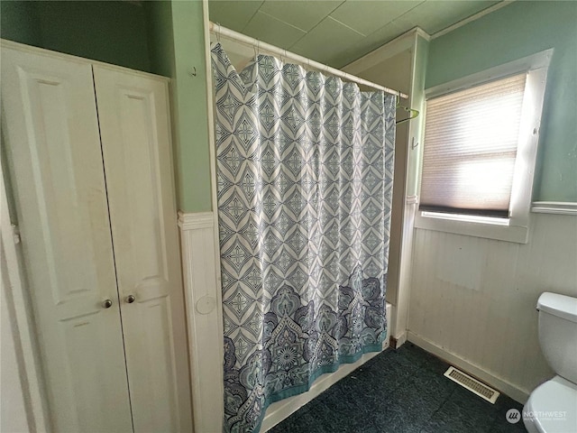 bathroom featuring shower / bath combination with curtain and toilet