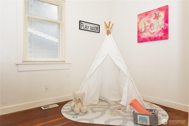 playroom with visible vents, baseboards, and wood finished floors