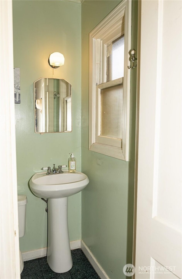 bathroom featuring toilet and baseboards