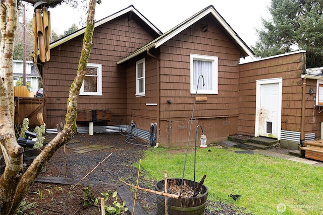 back of house featuring fence, crawl space, and a yard