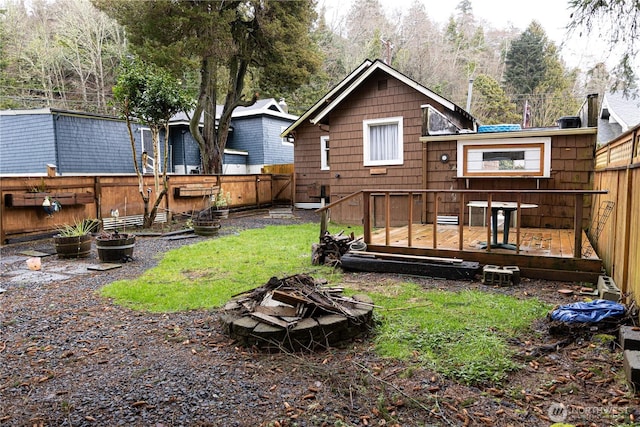 back of house with a yard, a fenced backyard, and a wooden deck