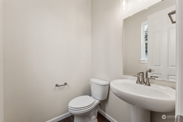 bathroom with toilet, sink, and hardwood / wood-style floors