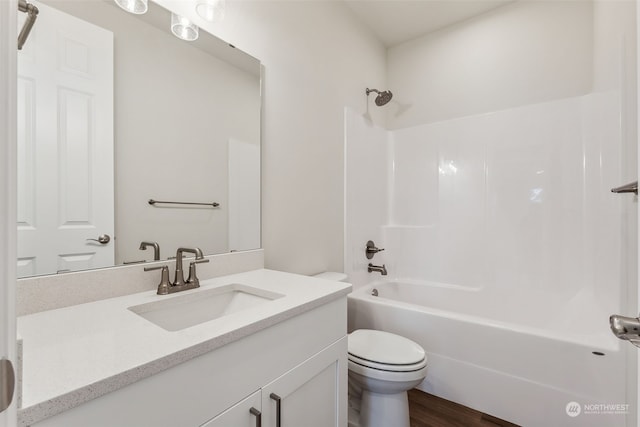 full bathroom featuring vanity, washtub / shower combination, hardwood / wood-style flooring, and toilet