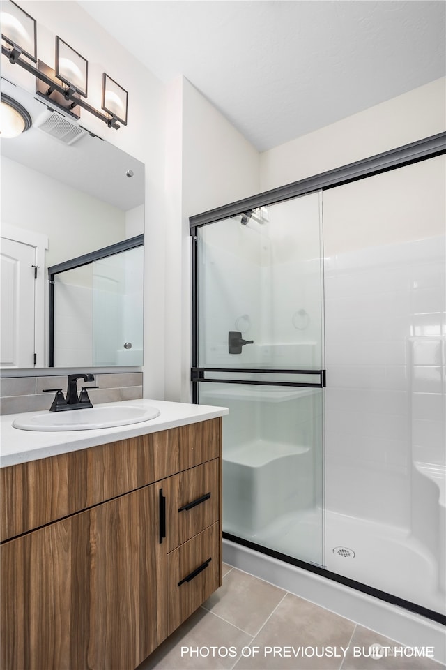 bathroom featuring vanity, a shower with door, and tile patterned floors