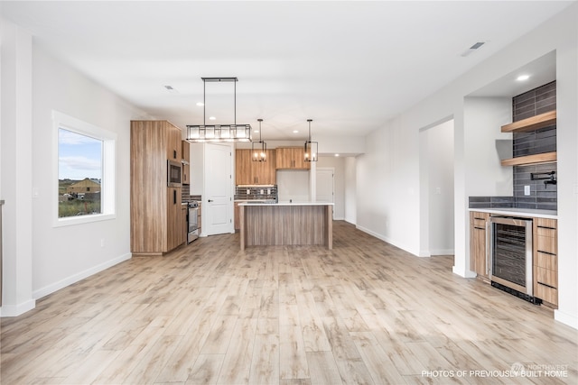 kitchen featuring a center island, hanging light fixtures, decorative backsplash, beverage cooler, and light hardwood / wood-style flooring