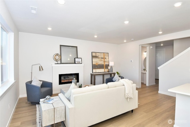 1112 SE 33rd St, Battle Ground, WA 98604 - living area with light wood-type flooring, a glass covered fireplace, recessed lighting, and stairway
