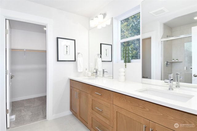 bathroom with tile patterned flooring, vanity, and a shower with shower door