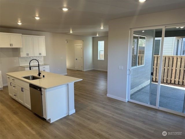 kitchen with white cabinetry, sink, tasteful backsplash, stainless steel dishwasher, and a kitchen island with sink