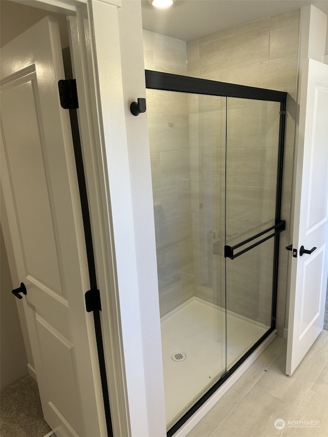 bathroom with tile patterned flooring and walk in shower