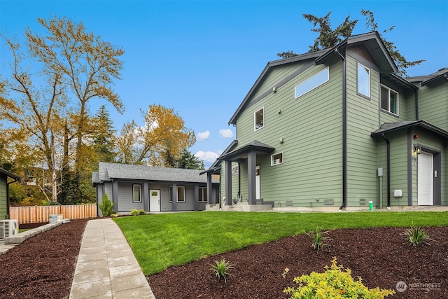 back of property with a garage and a lawn