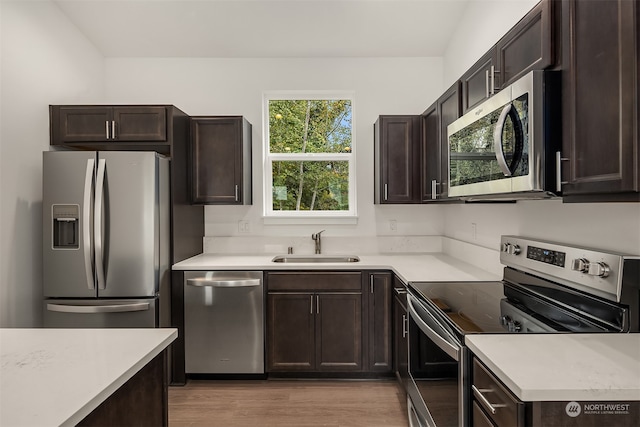 kitchen with a sink, stainless steel appliances, and dark brown cabinets