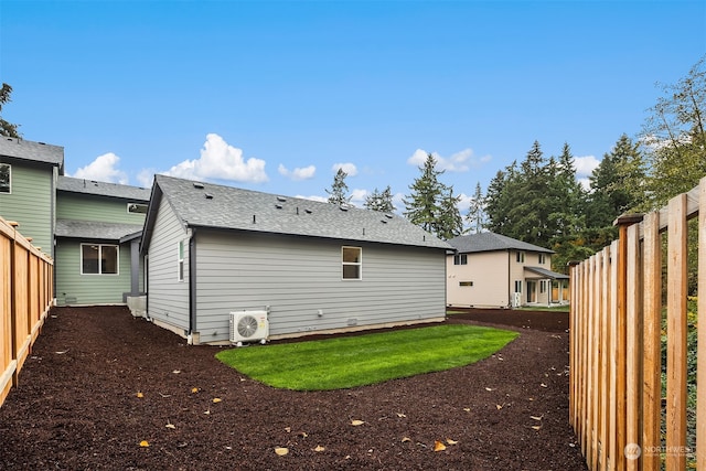 rear view of house with a shingled roof, fence, and ac unit