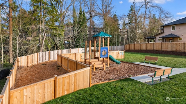 view of playground featuring a lawn and a fenced backyard