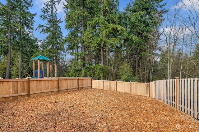 view of yard with a playground and a fenced backyard