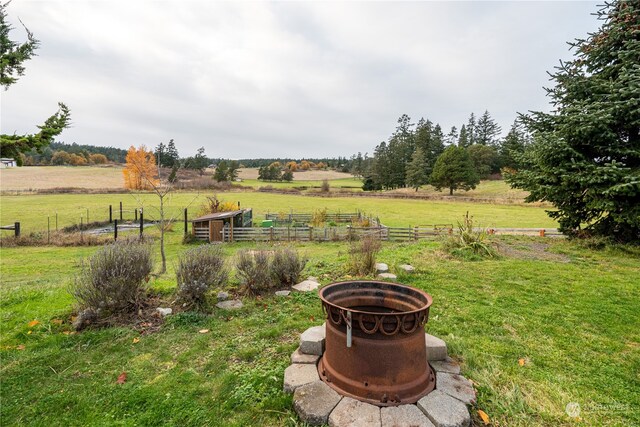 view of yard featuring a rural view and an outdoor fire pit