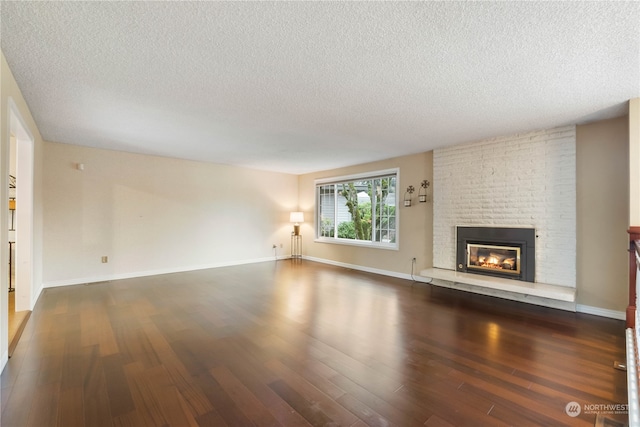 unfurnished living room featuring a textured ceiling, a fireplace, and dark hardwood / wood-style floors